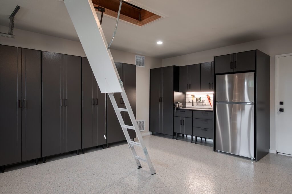 A modern kitchen with black appliances and a white attic ladder.