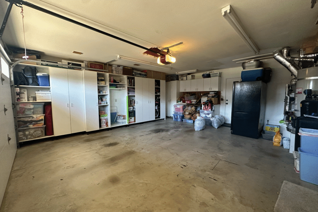 Organized garage with storage cabinets and bags on the floor.